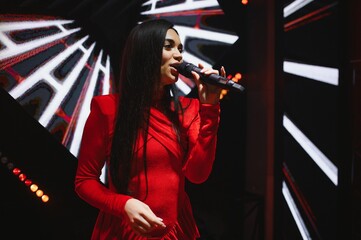 Woman singer performing with microphone on stage