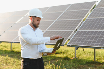 Engineer analyzing solar panel performance using laptop