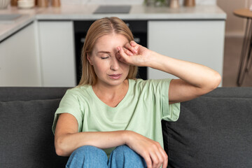 Obraz premium Woman feels discomfort from tired eyes and blurred vision at home during the day