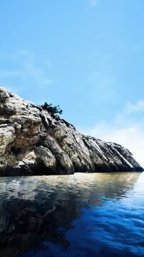 vertical cliff face reflected in glassy sea, rugged rock layers and bright sky, expansive horizon with subtle cloud streaks, moody contrast and bold coastal