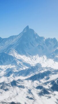 Snowcovered mountain peak under clear blue sky, sunlit ridges and distant glacier create dramatic alpine panorama, crisp cold air and pristine untouched slopes