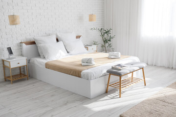 Interior of hotel room with bed, soft bench and lamps