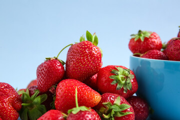 Heap of fresh ripe strawberries on blue background, closeup