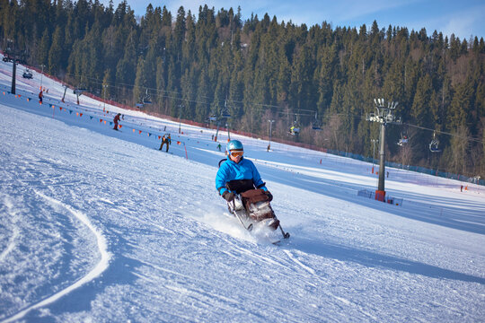 Active recreation in the mountains - a man in a blue jacket confidently skis down a mountain