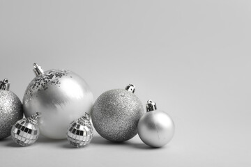 Silver Christmas baubles on grey background