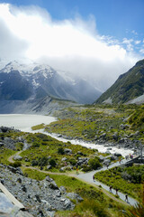 Fototapeta premium Hikers Walking Through Hooker Valley Track in Aoraki Mount Cook National Park