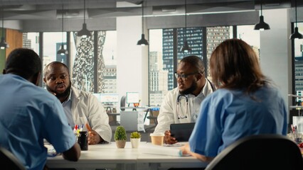 Obraz premium Medics attending healthcare team meeting to review patient care. The discussion focuses on treatment planning and advancement in modern medical clinic, professionalism.