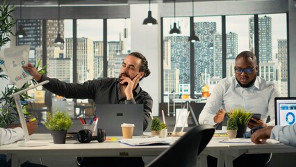 Business associates meeting to review budgeting and resource allocation in a briefing session. Multinational company work team analyzing data for strategic planning and growth.