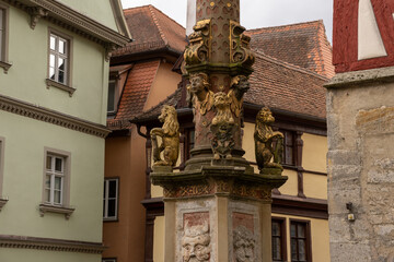 Obraz premium Marktplatz in Rothenburg ob der Tauber, Bavaria, Germany, featuring Town Hall Tower, Rathaus and Ratstrinkstube Clock Tower, surrounded by half-timbered houses, cobblestone streets and shops.