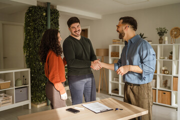 Fototapeta premium Couple shaking hands with real estate agent closing deal