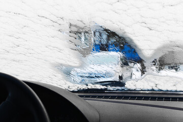 Frozen ice covering car windshield. Winter driving conditions inside vehicle. Limited visibility...