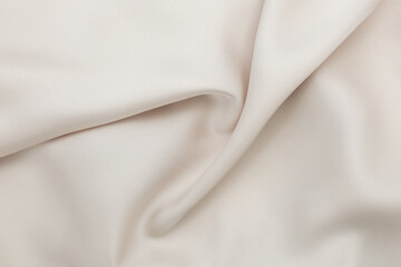 Close up view of soft beige fabric with a smooth texture in natural light