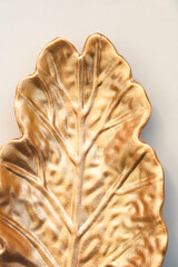 Decorative gold leaf plate on a wall for home decor and design ideas during daytime