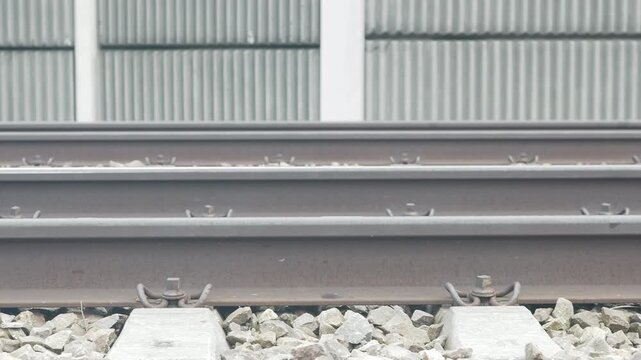 Railway track footage.  Concrete sleepers visible.  Metal rails connect.  Industrial scene.  Transportation infrastructure.  Construction or maintenance theme.  Suitable for backgrounds