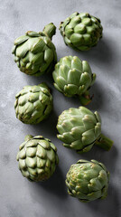Obraz premium Whole green artichokes arranged in a clean flatlay composition on a neutral background emphasizing natural texture and freshness. 