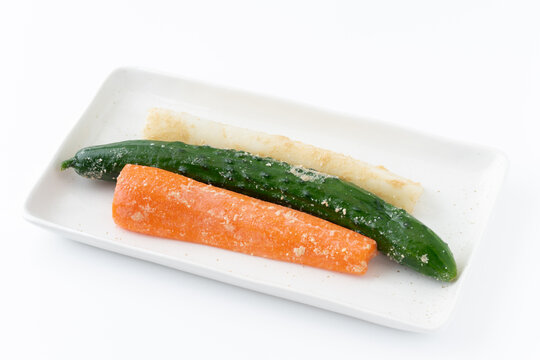 白背景にお皿に載せた人参と胡瓜と大根のぬか漬け