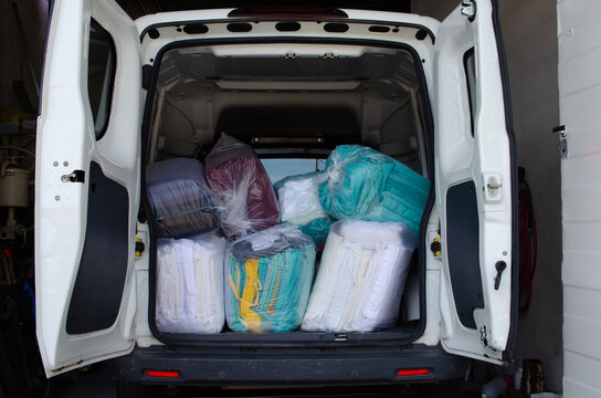 Utility vehicle loaded with clean clothes bags for delivery.
