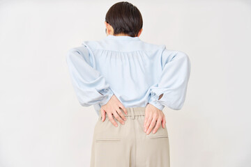 40代の女性　腰痛　白背景　後ろ姿