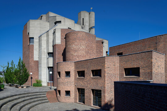 Exterior view of the sculptural St. Gertrud Catholic Church in Cologne, a brutalist masterpiece by Gottfried Boehm featuring concrete and red brick