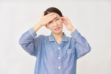 パジャマ姿の女性　発熱と頭痛　白背景