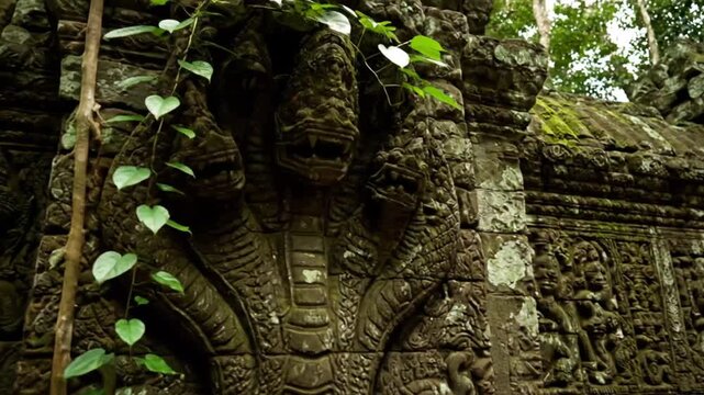 Ancient bas relief carvings at Ta Prohm temple in Angkor Wat Cambodia showing stone statues and naga heads