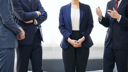 オフィスで立ち話するビジネスパーソンのグループ