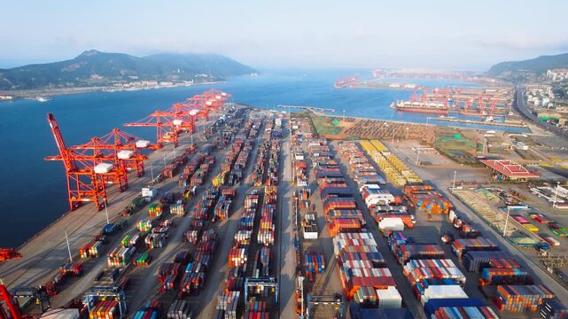 A dynamic aerial time-lapse capturing the pulse of global maritime trade, with massive container ships and synchronized cranes moving under dramatic skies.