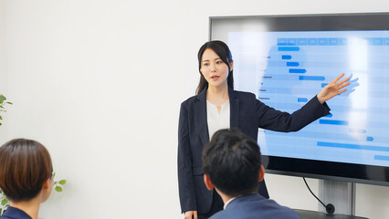 モニターを使ってプレゼンテーションする女性ビジネスパーソン