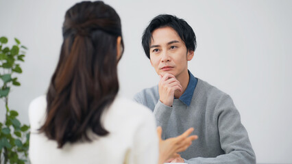 部屋で会話する男女カップル