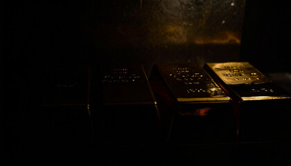 Obraz premium Dark conceptual photography of gold bars emerging from shadows inside a vault background