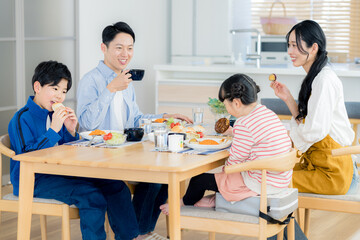 Obraz premium ダイニングで食事する4人家族