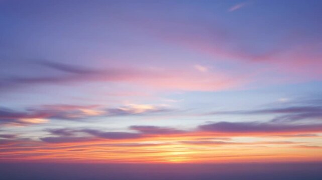 Vibrant pastel sunset sky with diffused cirrus clouds over open horizon