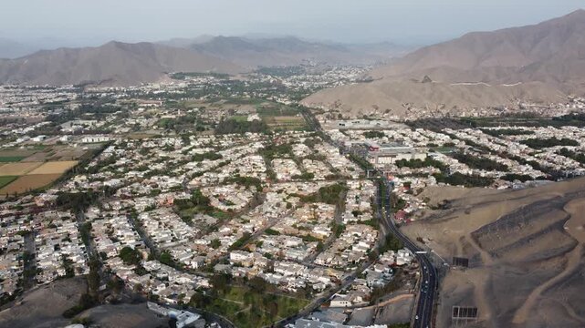 aerial panorama La Molina Lima Peru suburb reveals circular housing grid, dry hill slopes, white