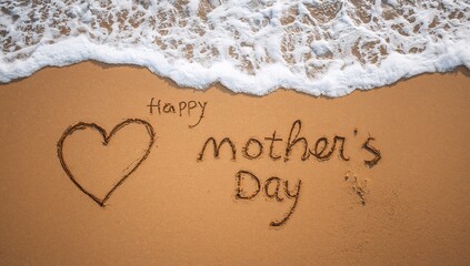A heart and happy mother s day written in the sand by the ocean