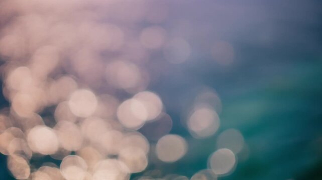 Abstract bokeh lights shimmering on a blurred water surface with soft warm and cool color gradients creating a serene atmosphere.