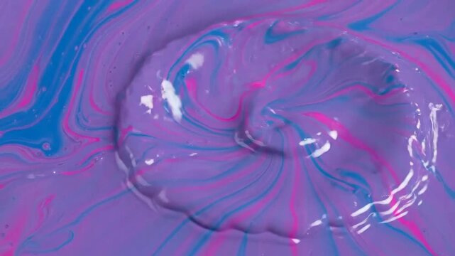 Vibrant liquid art featuring a splash of purple, blue, and pink hues creating dynamic patterns.