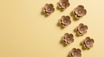 Obraz premium A clean yellow background decorated with handmade brown paper flowers, minimalist composition, soft lighting, flat lay style, simple and aesthetic look.