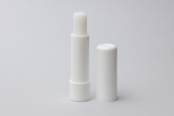 Mockup of white tube of lip balm on gray background. Hygienic lipstick