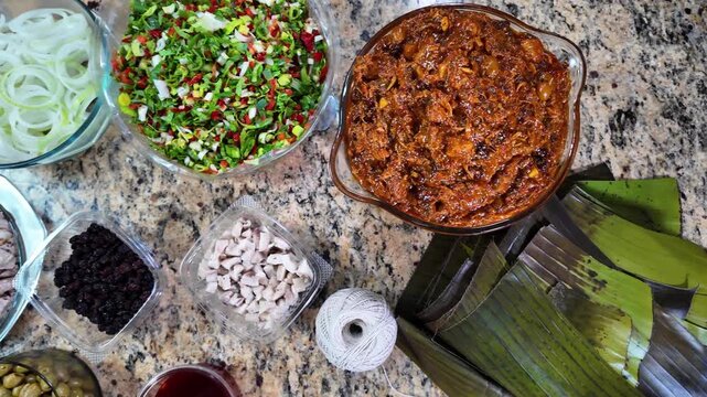Traditional recipe.Top down Common ingredients such as ground meat (pork and beef), sliced ​​onions, diced red bell peppers, spice blends, sofrito, and the use of banana leaves