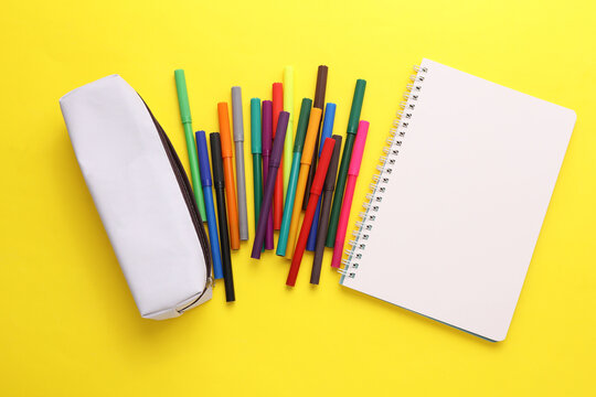 White pencil case mockup with colored markers on a yellow background