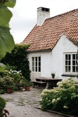 White Cottage with Red Tile Roof and Garden Patio house
