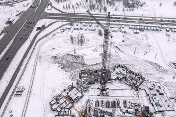 construction site with building crane in winter time. aerial drone photo.
