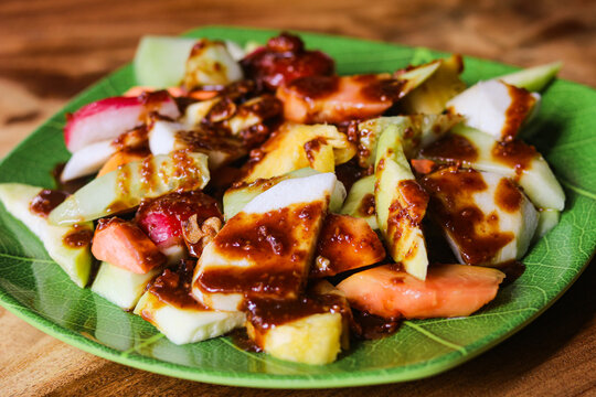 A serving of Rujak (Roejak), a traditional Indonesian dish featuring assorted fresh fruits and vegetables, with a sweet and spicy peanut sauce.