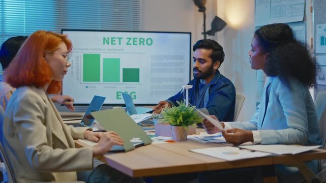 group of multiethnic businesspeople in team meeting,using tablet computer for Net zero,ESG topic presentation on monitor. Sustainable business practice,global warming,earth day,ESG team concept