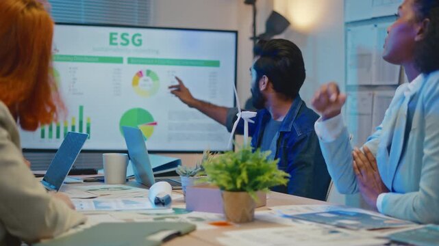 group of multiethnic businesspeople in team meeting,using tablet computer for Net zero,ESG topic presentation on monitor. Sustainable business practice,global warming,earth day,ESG team concept