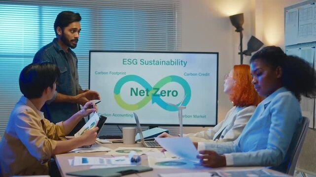 group of multiethnic businesspeople in team meeting,using tablet computer for Net zero,ESG topic presentation on monitor. Sustainable business practice,global warming,earth day,ESG team concept