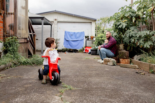 Toddler boy riding his trike in the backyard