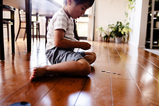 Young boy counting money on the floor