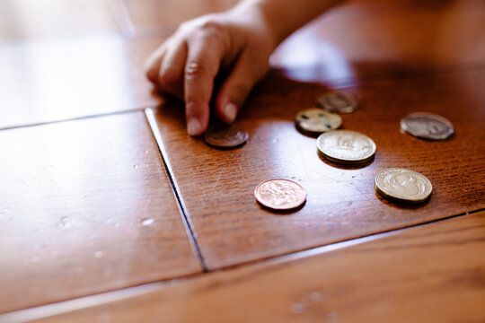 Young boy counting money on the floor