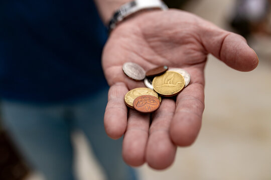 Close up of a hand holding several coins